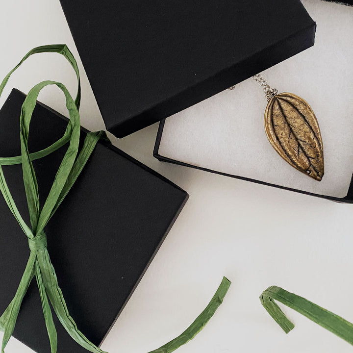 packaging black gift box with green natural ribbon and bronze leaf necklace